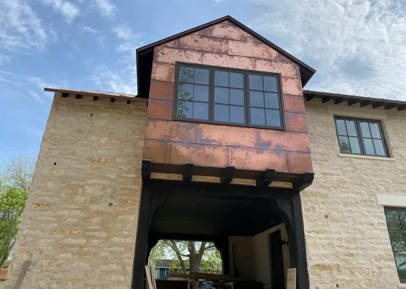 Copper metal panel facade on a stone building for Roof Repair in Polk